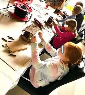Kinder beim Basteln von Krippen mit Holz